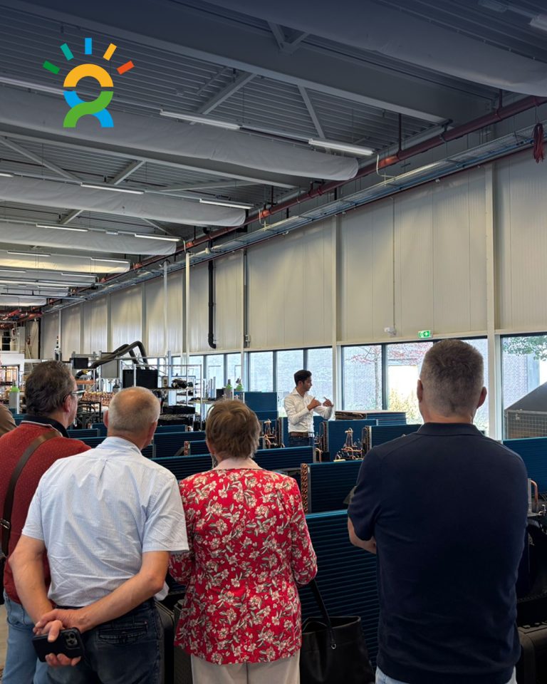 Bezoekers tijdens een rondleiding door de WeHeat fabriek, georganiseerd door De Groene Generatie, waar ze uitleg krijgen over warmtepompen en productie.